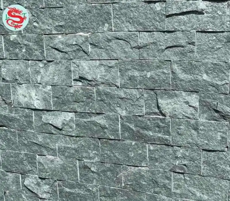 Đá xanh Thanh Hóa ốp tường, với màu xanh rêu nổi bật, đá được chẻ tay tự nhiên, tạo điểm ghồ ghề trên mặt đá, dùng để ốp chân tường hoặc hàng rào.